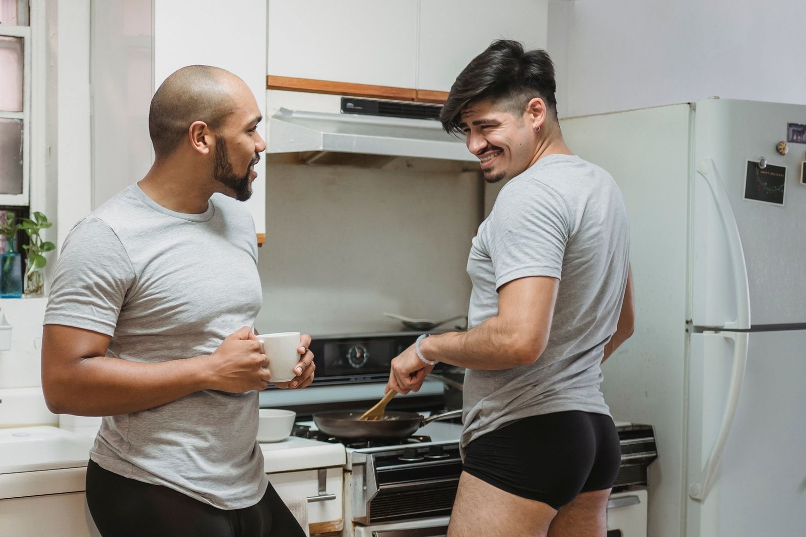 two boxer briefs laid flat, one with a rolled leg and one with a flat leg, measuring tape showing inseam difference